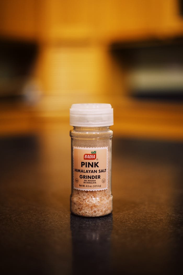 Close-up of a Badia pink Himalayan salt grinder with blurred background.